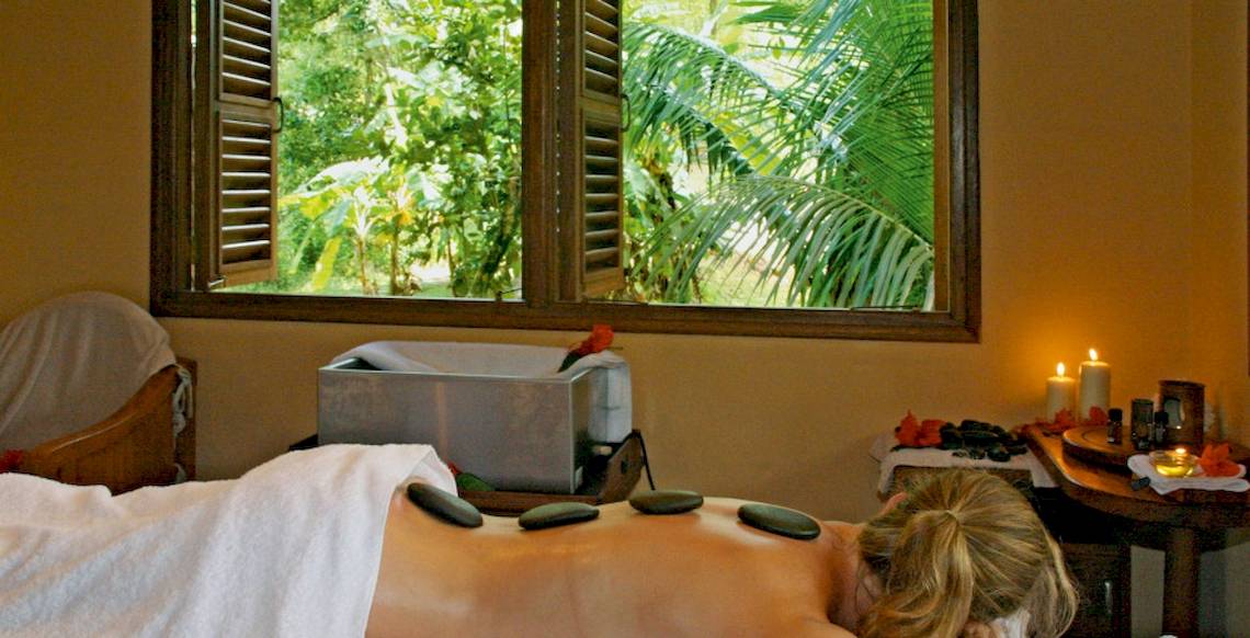 Eine Frau erhält eine Massage im Hotel Cerf Island Resort mit Blick auf den Garten.