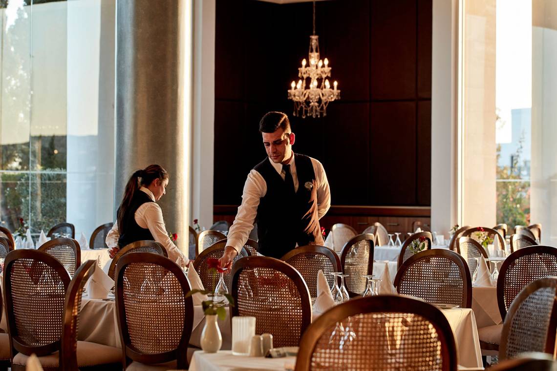 Bedienung im Hotelrestaurant Grecian Park bereitet Tische vor