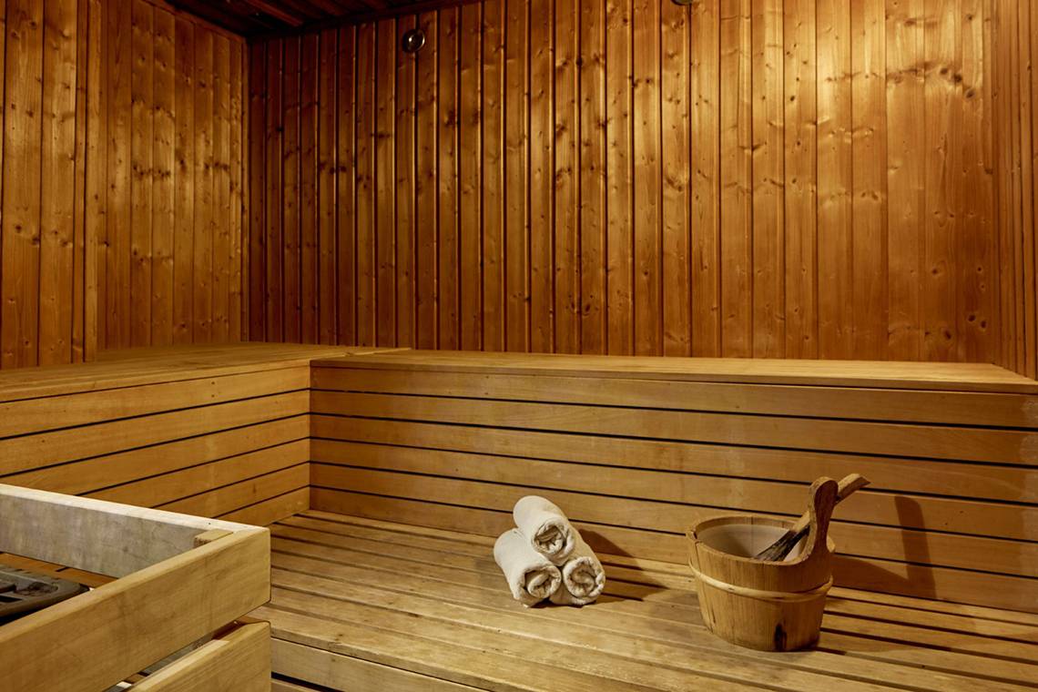 Eine Holzsauna im Grecian Park Hotel mit Holzbänken und Handtüchern.
