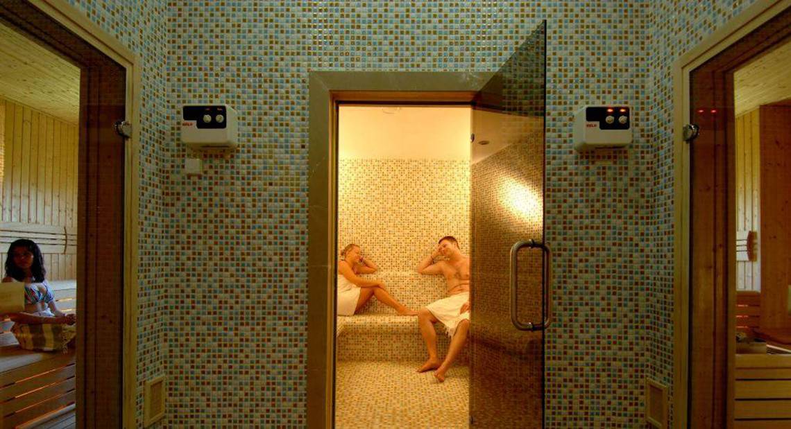 Sauna im Orange County Belek - Family Concept Hotel mit zwei Personen und einer Frau, die beobachtet
