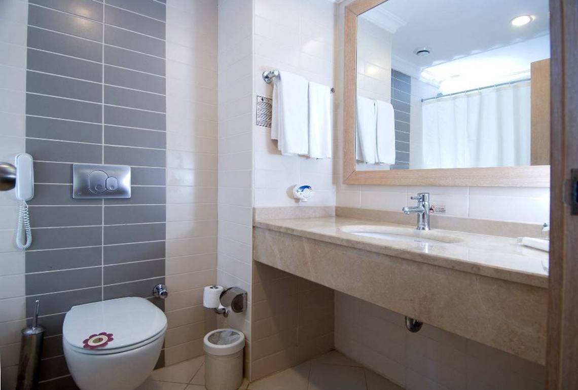 Badezimmer im Orange County Belek Hotel mit Toilette, Waschbecken und Spiegel.