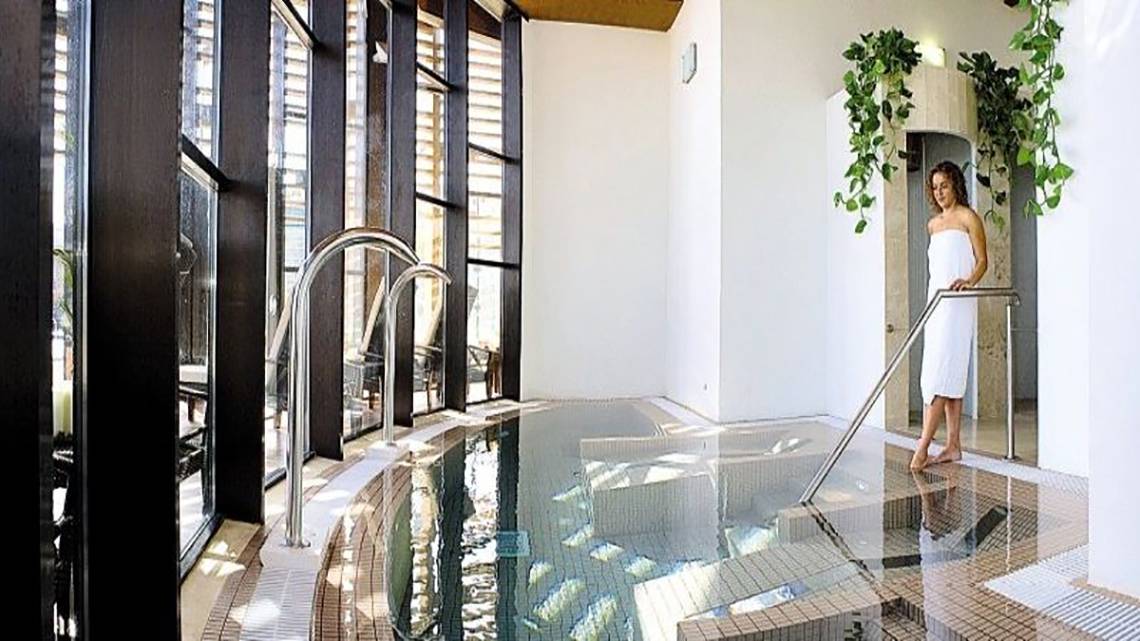 Eine Frau im weißen Handtuch steht neben dem Innenpool im Barcelo Tenerife Hotel.