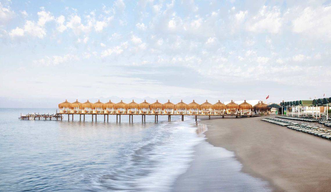 Außenbereich des Kremlin Palace Hotels mit Sonnenschirmen und Liegestühlen am Strand