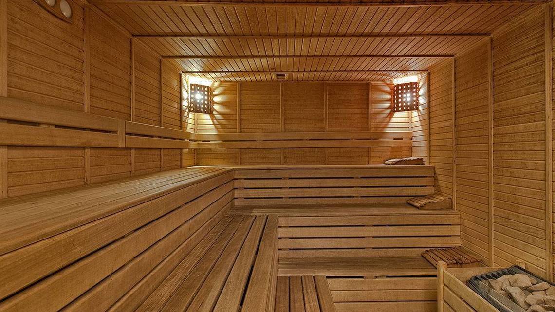 Innenansicht der Sauna im Kremlin Palace Hotel mit hölzernen Bänken und Beleuchtung.