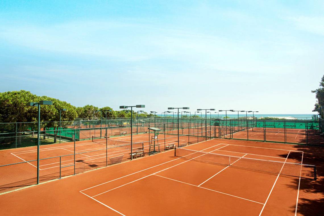 Tennisplatz im Freien mit Blick auf das Meer und Bäume am Kremlin Palace Hotel.