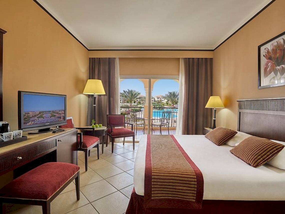 Hotelzimmer im Jaz Mirabel Beach mit Poolblick, Fernseher, und bequemen Möbeln.
