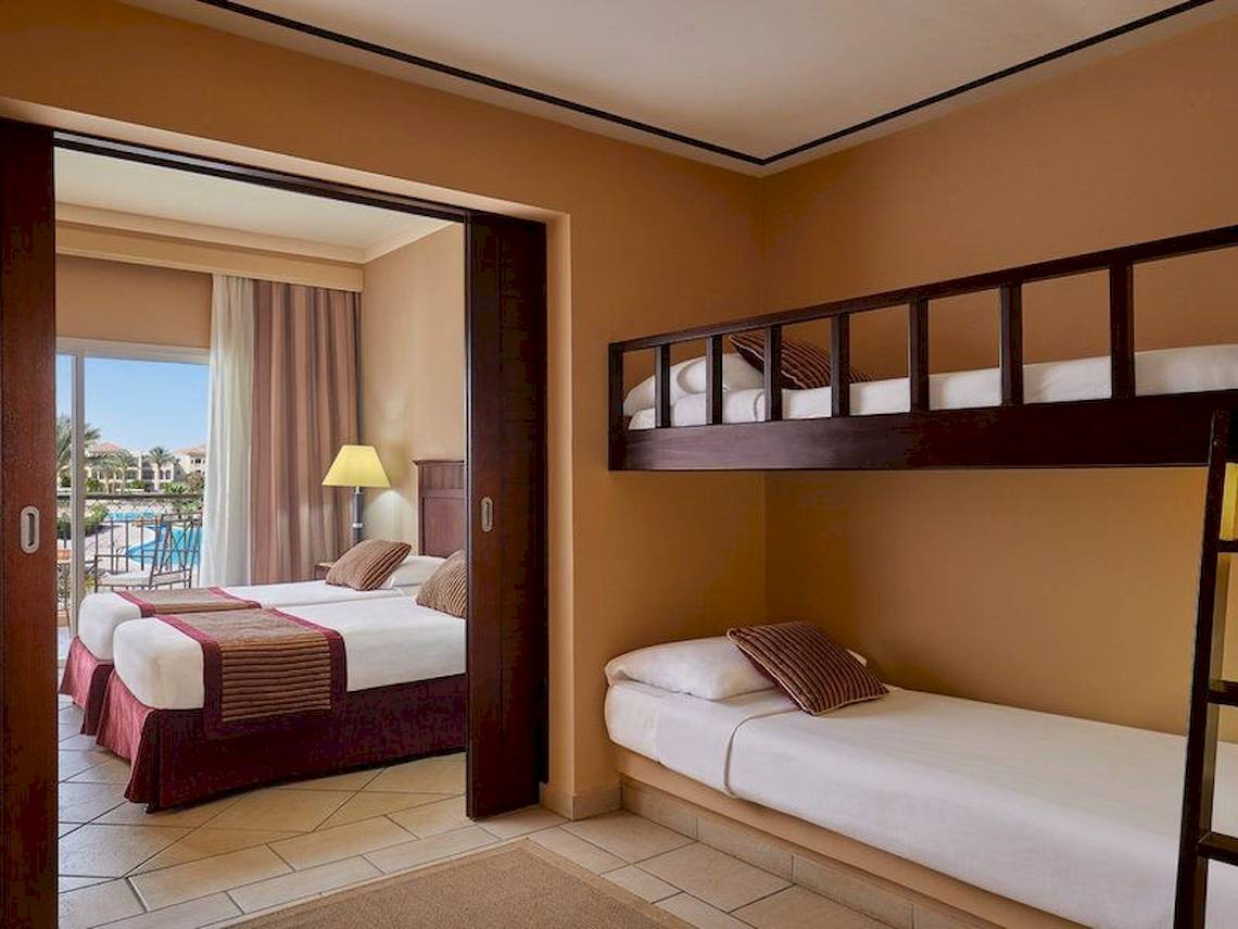 Doppelzimmer im Jaz Mirabel Beach Hotel mit zwei Betten und einem Etagenbett.
