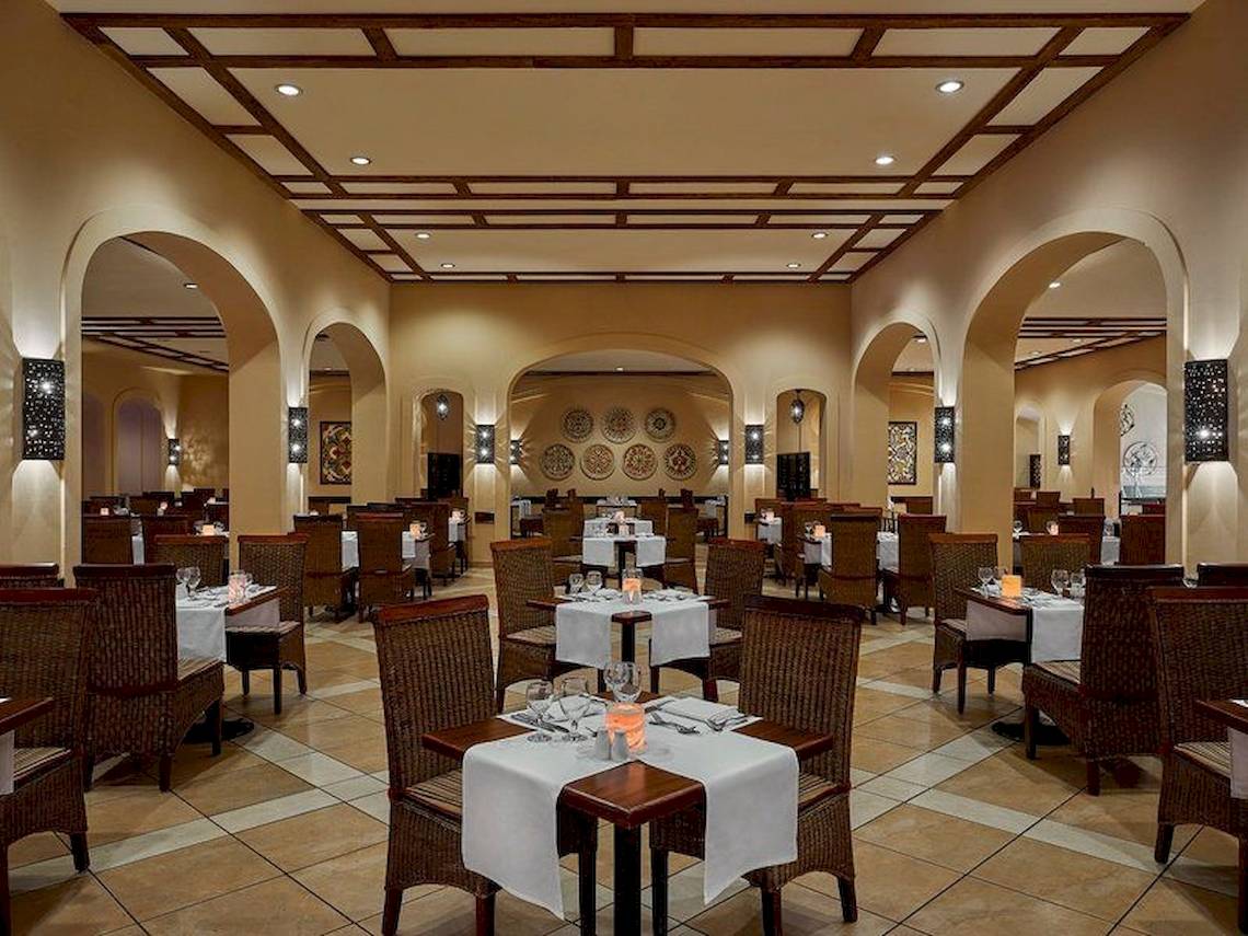 Innenansicht des Jaz Mirabel Beach Restaurants mit gedeckten Tischen und Stühlen.