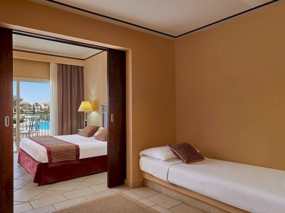 Zimmer im Jaz Mirabel Beach Hotel mit zwei Betten, Balkon und Poolblick.