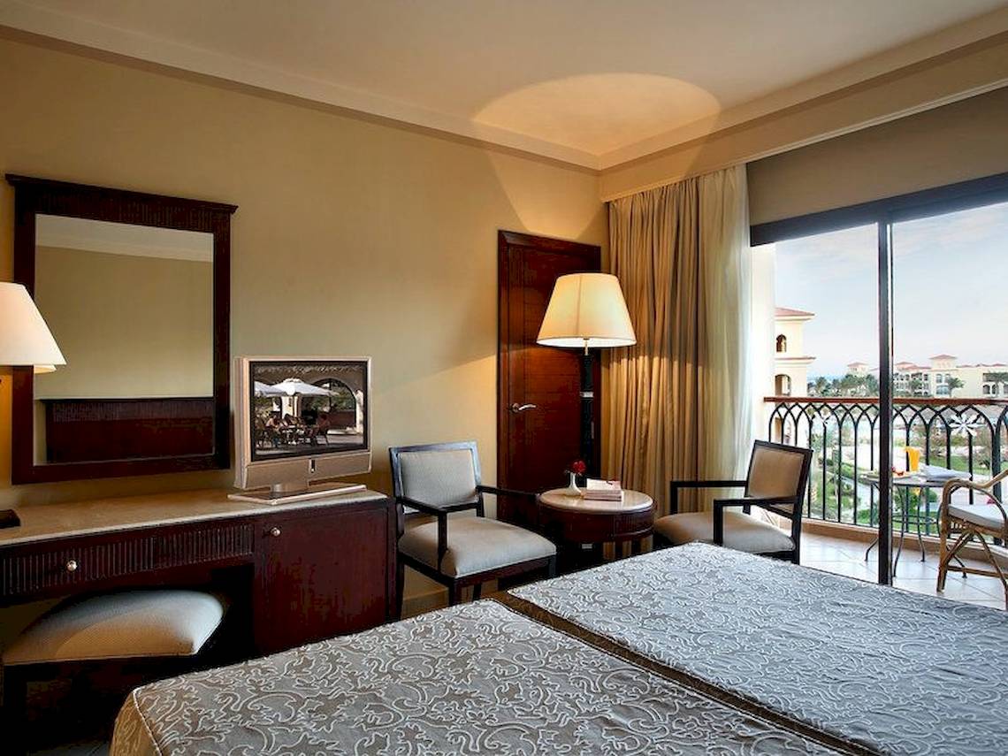 Doppelzimmer im Jaz Mirabel Beach Hotel mit zwei Betten, Schreibtisch, Fernseher und Balkon.