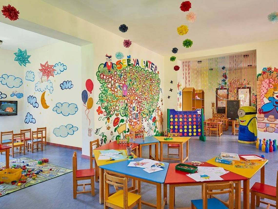 Kinderzimmer im Jaz Mirabel Beach Hotel mit bunten Wandgemälden, Tischen und Stühlen für Aktivitäten.