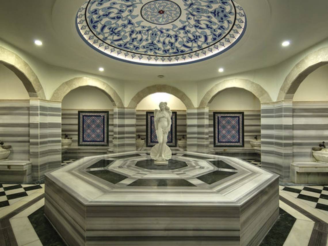 Innenbereich der Sauna im Sunrise Queen Luxury Resort & Spa mit einer zentralen Marmorstatue und dekorativen Wandfliesen.