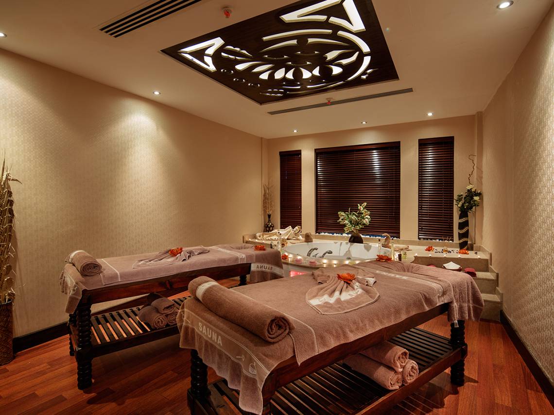 Saunaraum im Sunrise Queen Luxury Hotel mit zwei Massagetischen und einer Badewanne.
