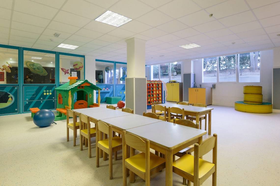 Kinderspielbereich im Leonardo Royal Hotel Ibiza Santa Eulalia mit bunten Möbeln und Spielzeug.