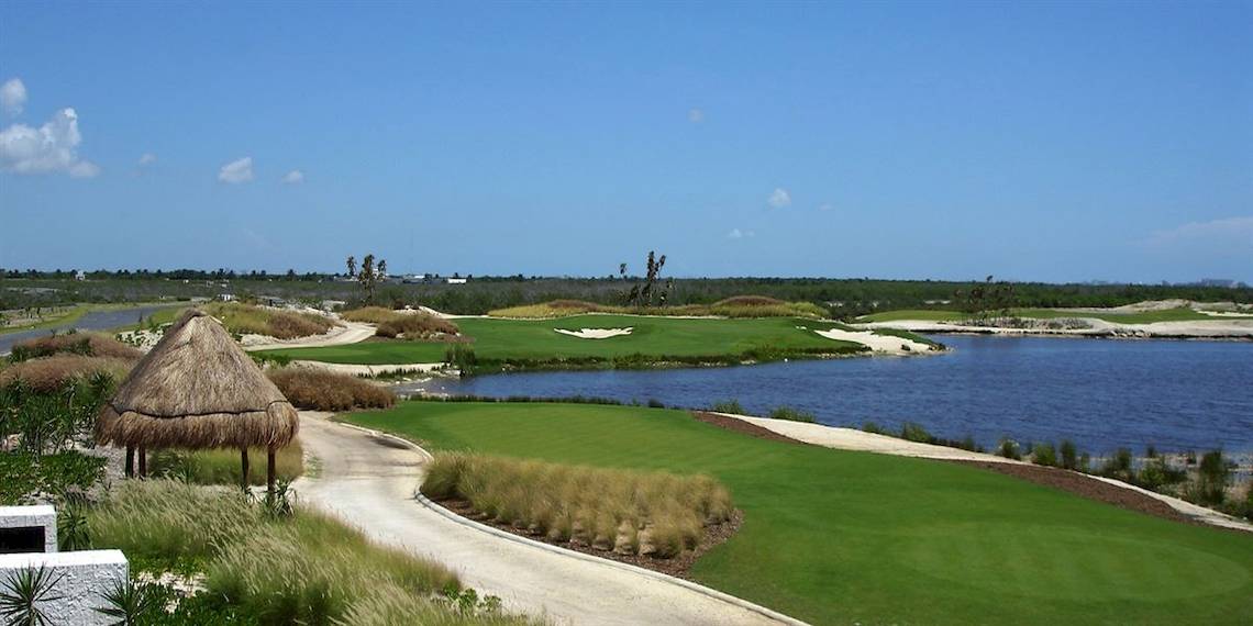 Aussicht auf den Golfplatz des Hard Rock Hotel Cancun mit einem Wasserhindernis und einer kleinen Hütte.