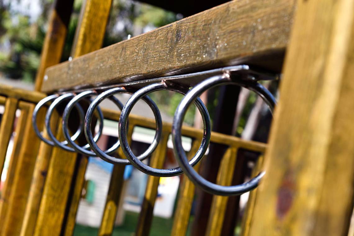 Ein Bild zeigt goldene Ringe, die an einem Spielplatz befestigt sind.