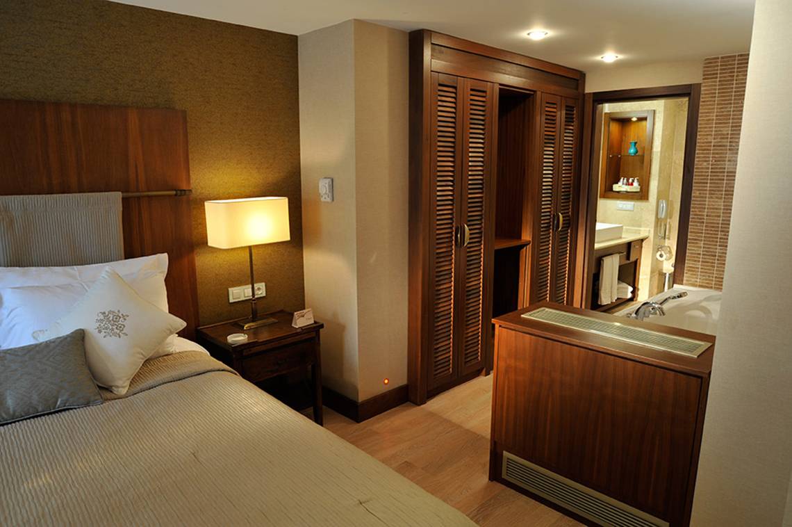 Hotelzimmer im Marti Resort mit Bett, Nachttisch und Badewanne
