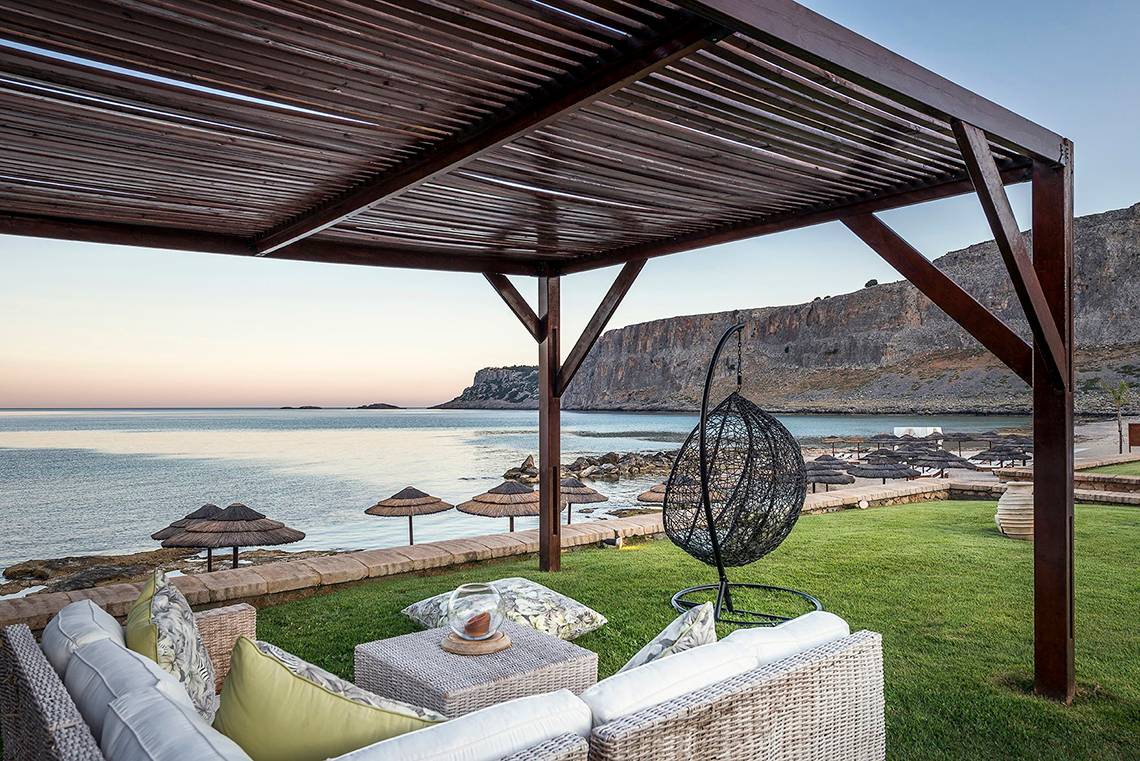 Terrasse im Mitsis Lindos Memories Resort & Spa mit Blick auf das Meer und Felsen