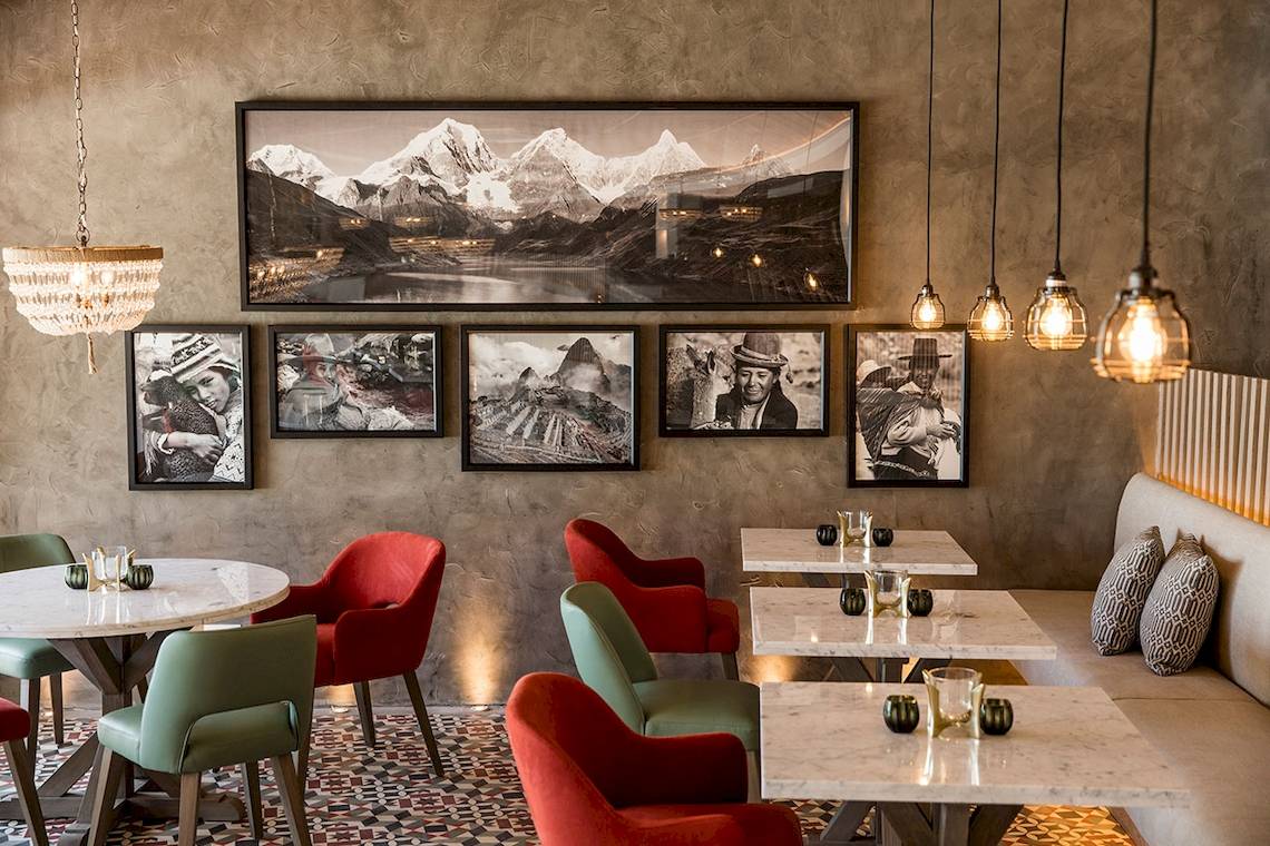 Innenbereich des LUX Grand Gaube Resort & Villas mit Tisch, Stühlen und einer Bilderwand.