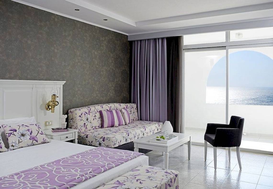 Doppelzimmer mit Meerblick im Esperos Village Blue & Spa mit luxuriösem Interieur, Kingsize-Bett, Wohnzimmerbereich und Balkon mit Meersicht.