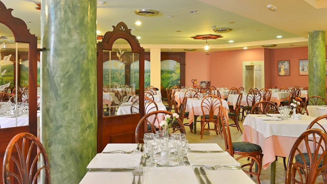Innenansicht des Restaurants im Iberostar Tainos Hotel mit gedeckten Tischen und Stühlen.