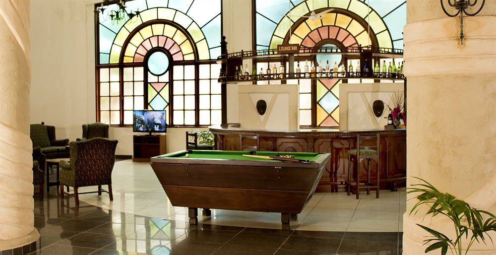 Pooltisch im Neptune Beach Resort Loungebereich mit bunten Glasfenstern im Hintergrund.