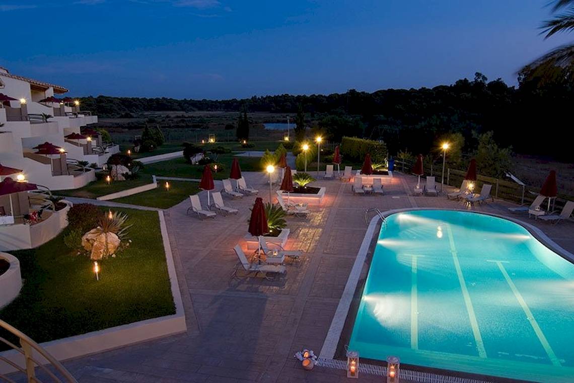 Nachtansicht des Außenpools und der Loungesessel des Verde Al Mare Hotels.