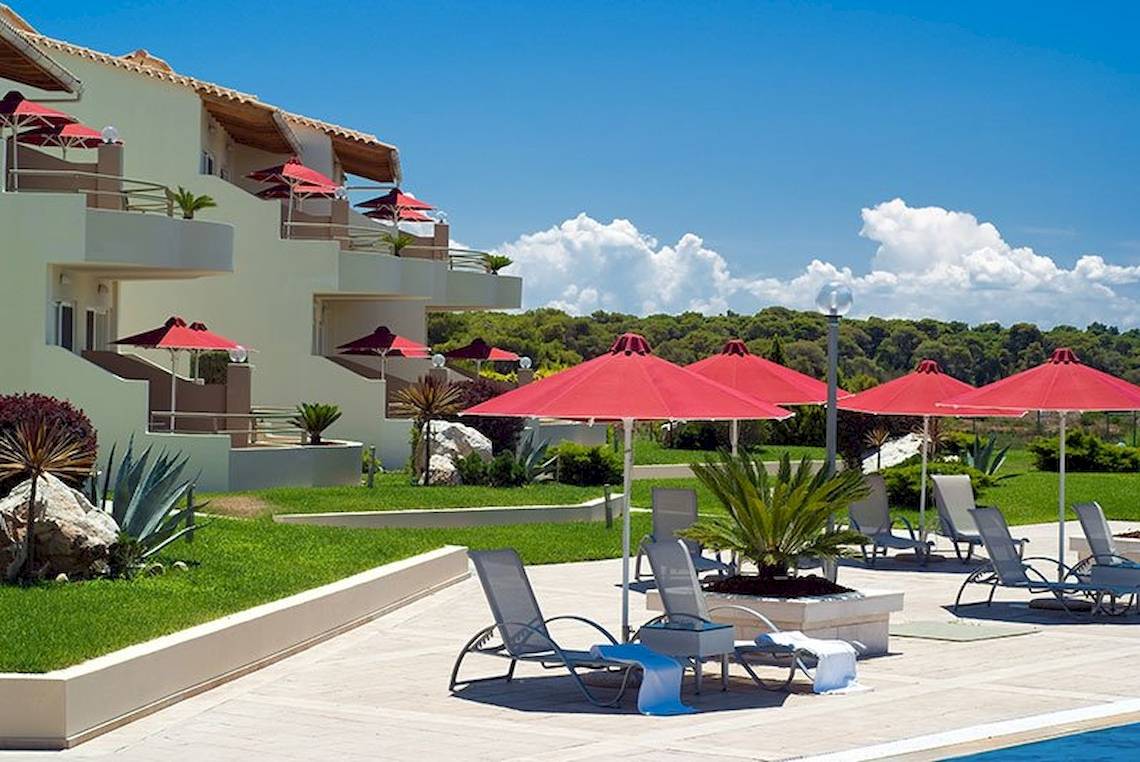 Poolbereich des Verde Al Mare Hotels mit roten Sonnenschirmen und Liegestühlen