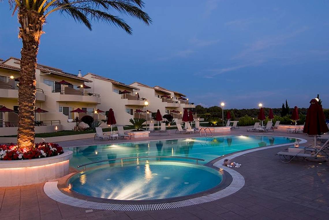 Der Außenpoolbereich des Verde Al Mare Hotels bei Nacht mit Loungestühlen und Palme
