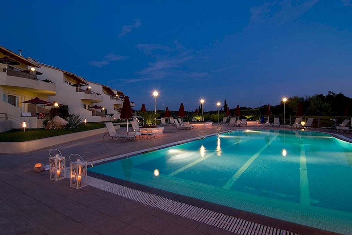 Pool im Hotel Verde Al Mare bei Nacht, mit Loungestühlen und Laternen.