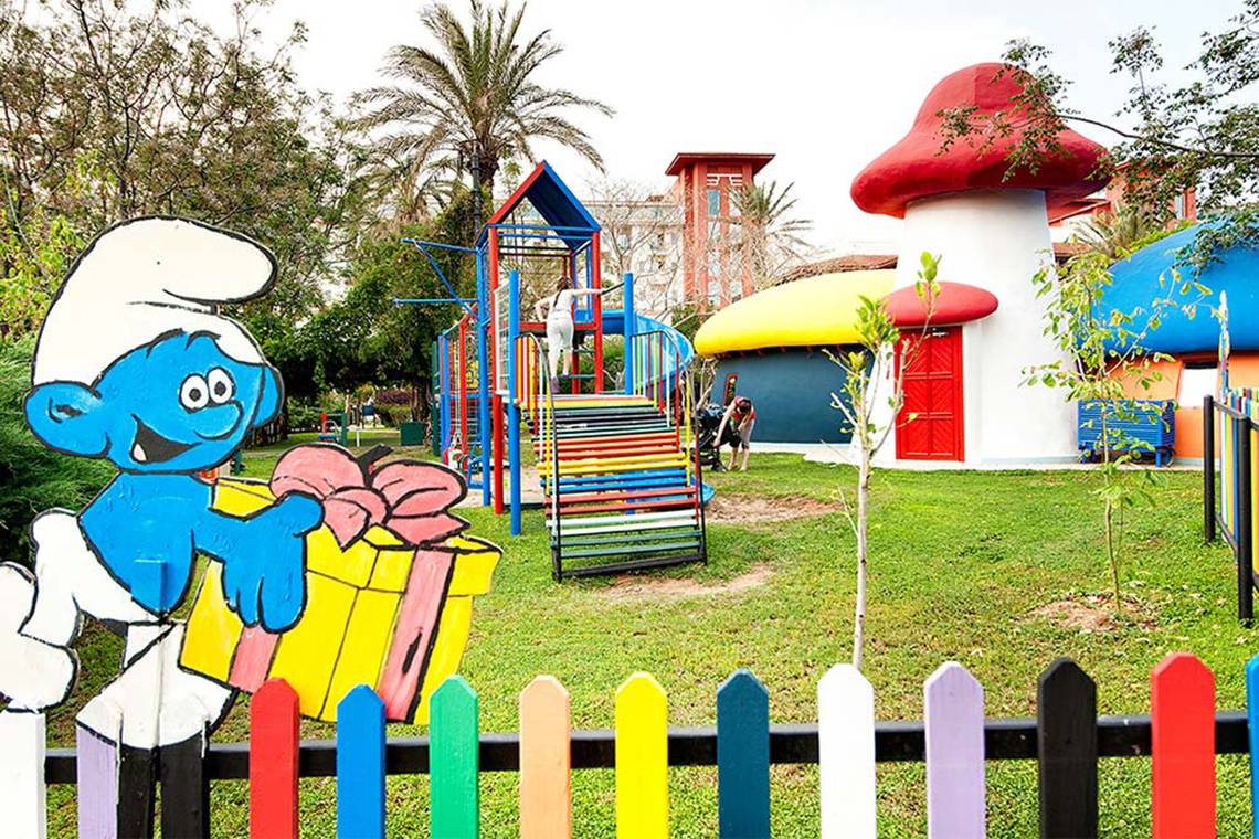 Kinderspielplatz im Belconti Resort mit bunten Schläuchen, Schlitten und Schmückfiguren.
