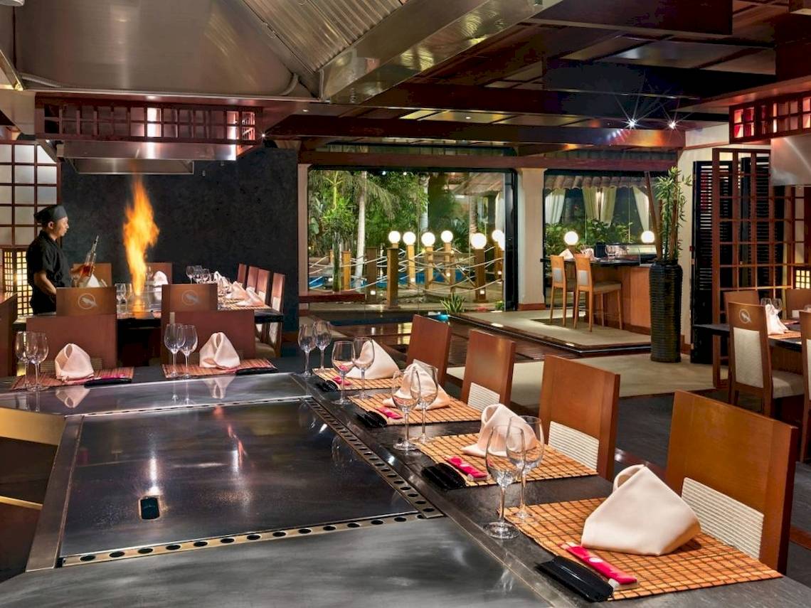 Restaurant des Secrets Bahia Real Resort & Spa mit einem Koch am Grill und gedeckten Tischen