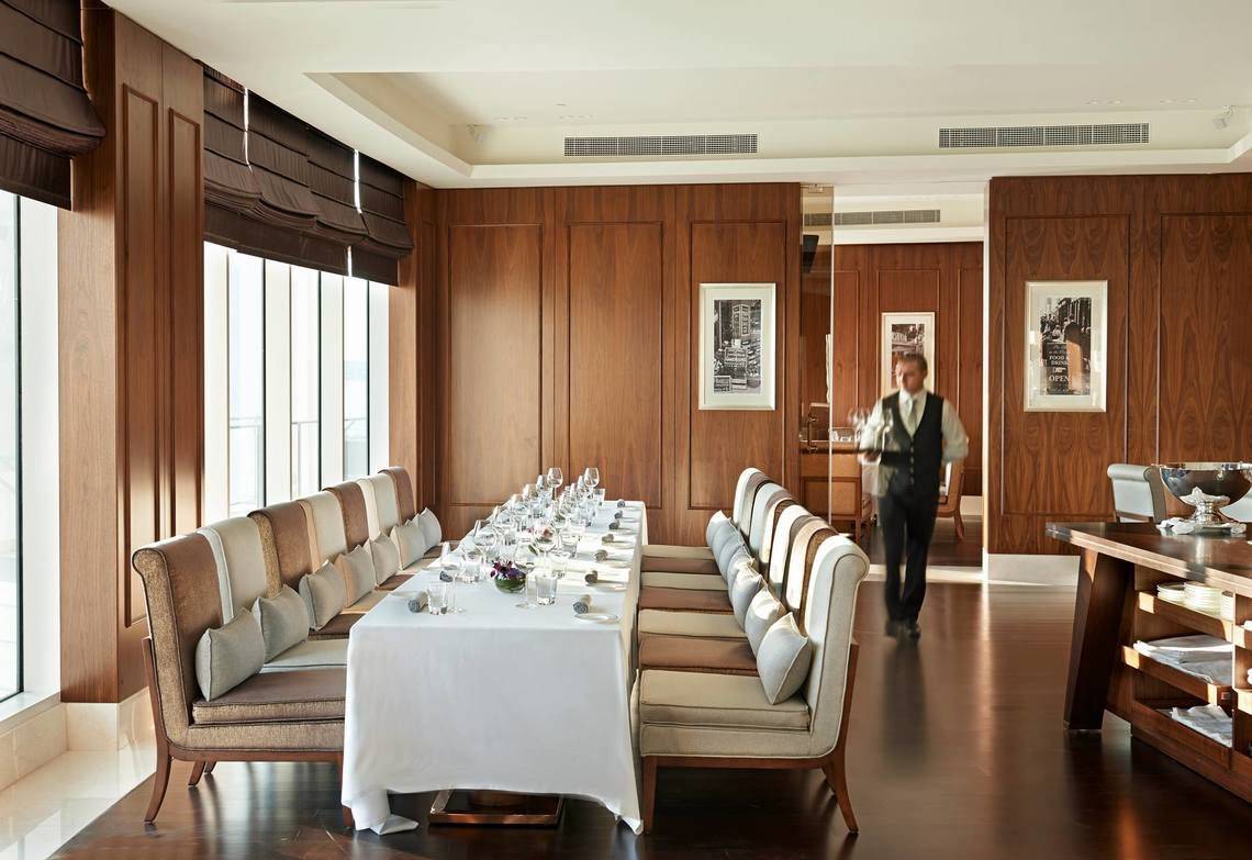 Speisesaal im Waldorf Astoria Dubai Palm Jumeirah mit Holzwänden und großen Fenstern.