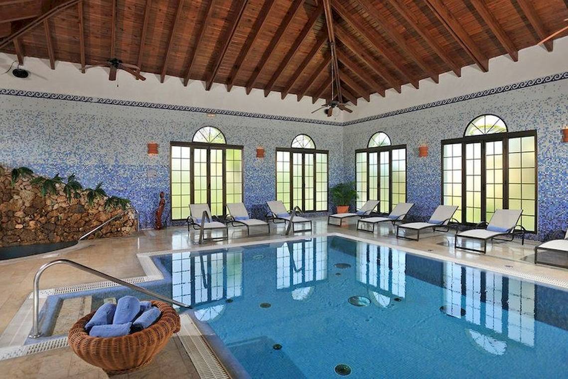 Innenpool im Bahia Principe Grand Turquesa Hotel mit Liegestühlen und blauen Mosaikwänden.