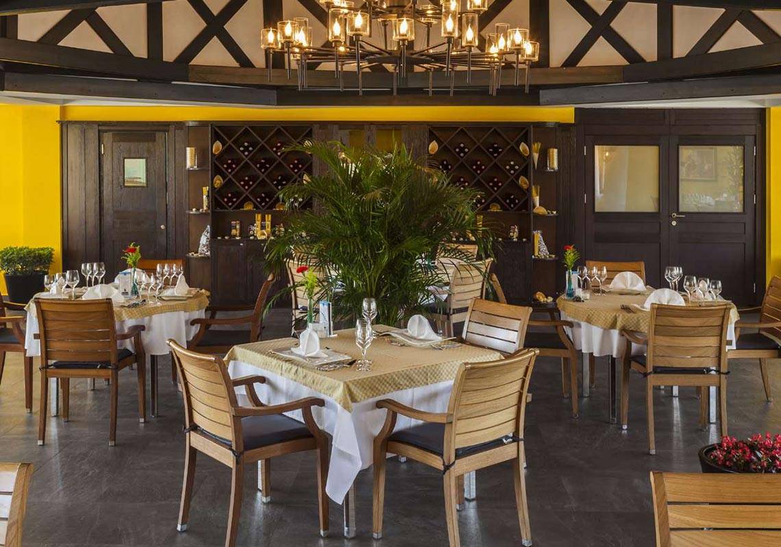 Innenansicht des Restaurants im Magic Life Belek mit gedeckten Tischen und gelben Wänden.