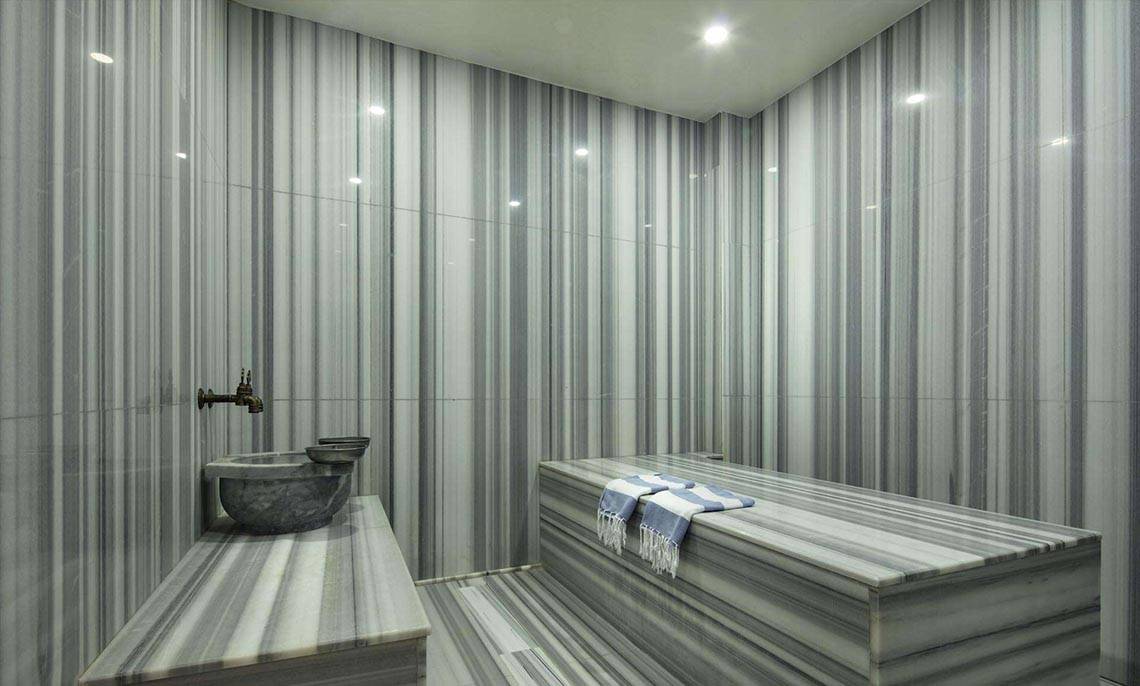 Innenraum des Dampfbads im Magic Life Belek Hotel mit Marmorwänden und einer Badewanne.