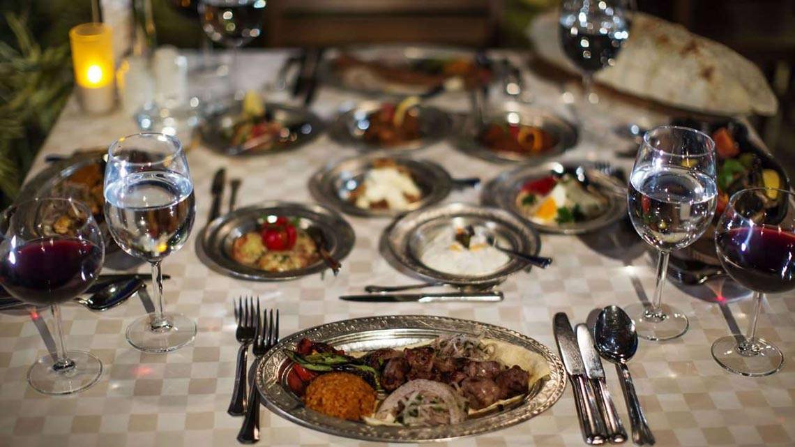 Essen auf dem Tisch im Magic Life Belek Hotel mit verschiedenen Gerichten, Weingläsern und Besteck.