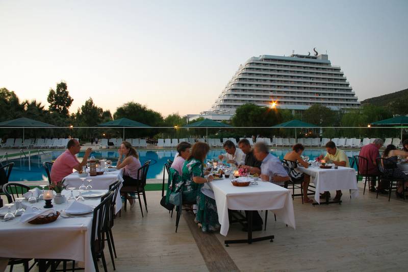 Gäste am Tisch im Außenbereich des Palm Wings Ephesus Beach Resorts