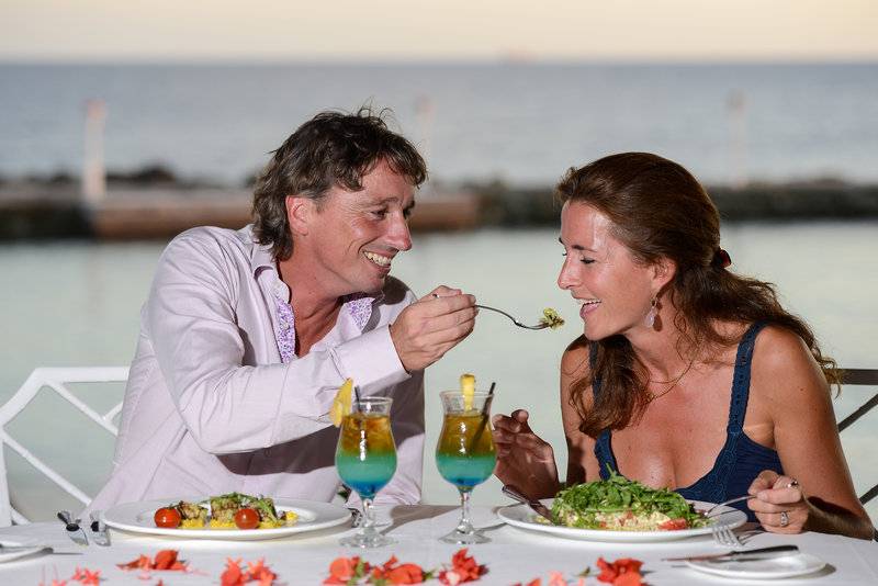 Mann und Frau essen am Tisch im Avila Beach Hotel mit Blick auf den Ozean.