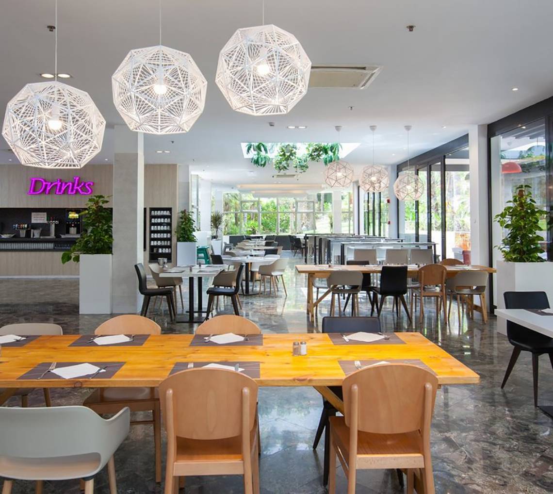 Frühstücksbereich im Abora Catarina Hotel mit modernen Möbeln und Pflanzen.