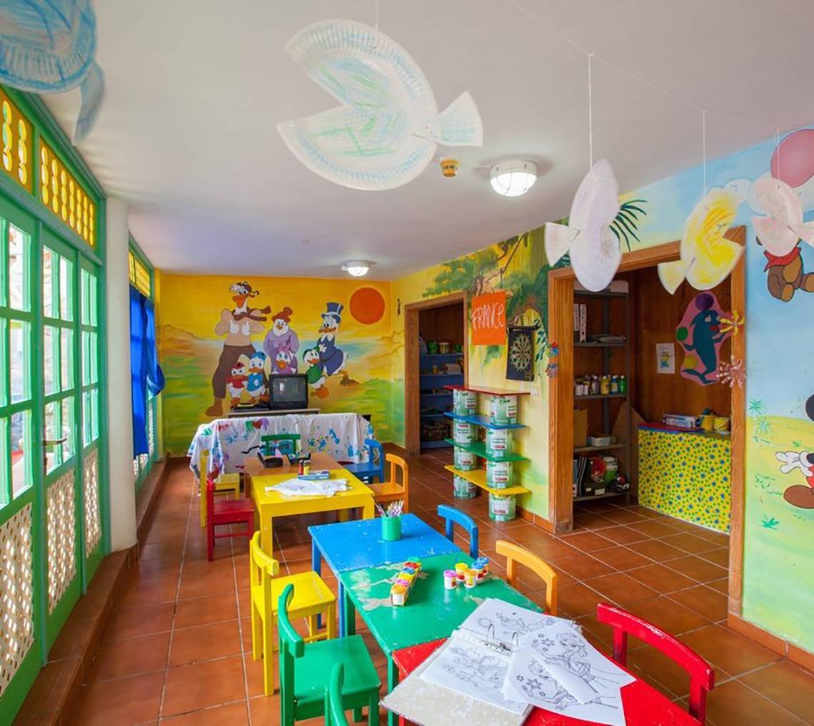 Innenansicht des Kinderzimmers im Abora Catarina Hotel mit bunten Tischen und Stühlen.