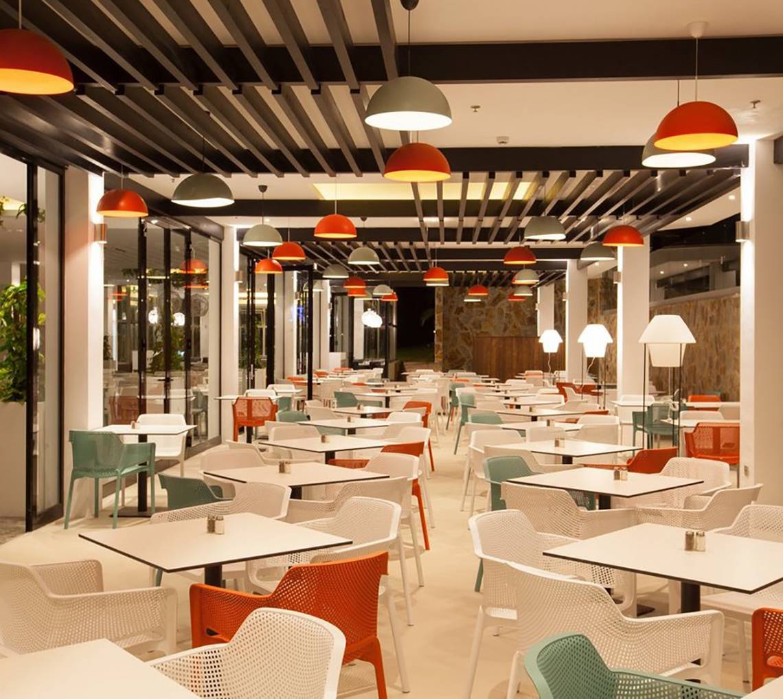 Innenansicht des Restaurants im Abora Catarina Hotel mit vielen bunten Stühlen und Tischen.