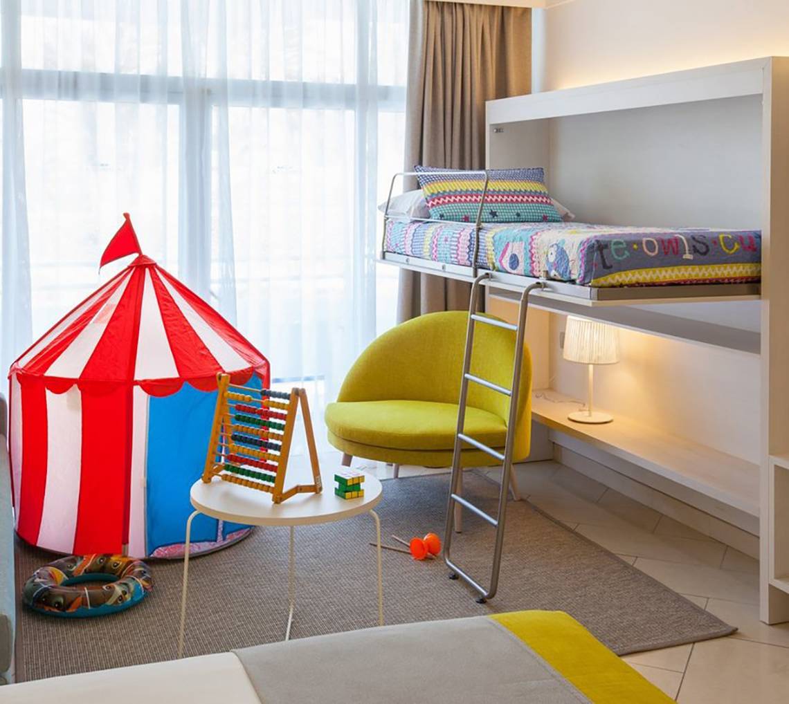 Kinderzimmer im Abora Catarina Hotel mit Doppelbett, Spielzelt und Spielzeug.