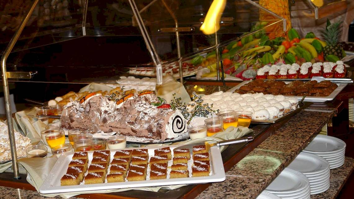 Buffet im Acrotel Athena Pallas mit verschiedenen Desserts, Früchten und Getränken.