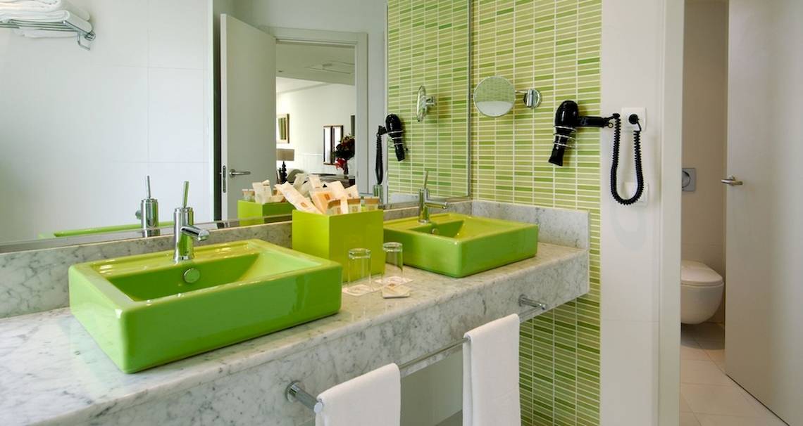 Badezimmer im Vincci Tenerife Golf Hotel mit grünen Fliesen und zwei Waschbecken.