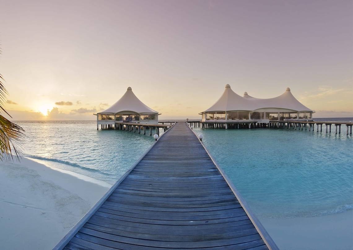 Safari Island Resort am Wasser mit zwei weißen Zelten und einem Holzsteg