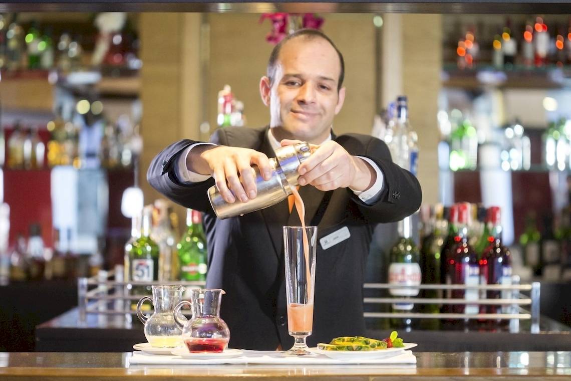 Ein Barkeeper bereitet einen Cocktail im Hipotels Cala Millor Park zu.