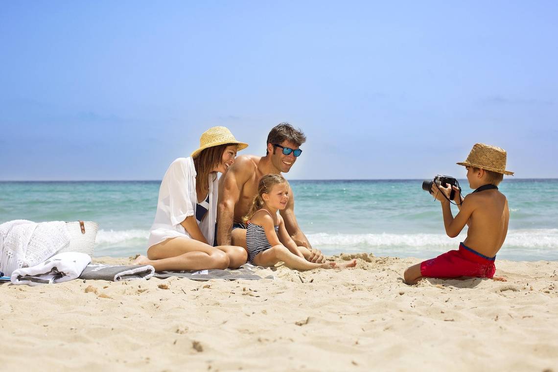 Familie auf dem Hipotels Cala Millor Park Strand mit einer Kamera