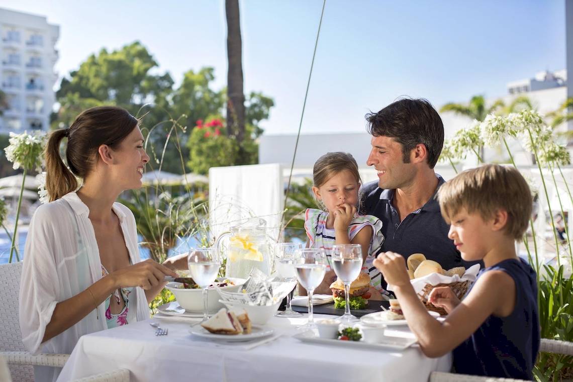 Eine Familie sitzt bei einem Essen im Hipotels Cala Millor Park Hotel.