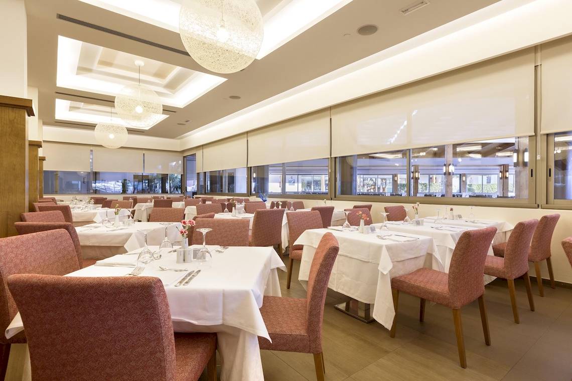Restaurant des Hipotels Cala Millor Park mit gedeckten Tischen und Stühlen.